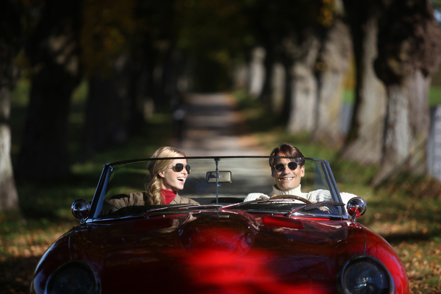 Man and Woman riding in a red car