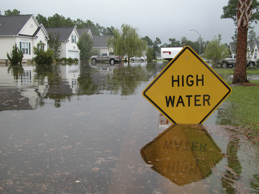 Flooded street with sign that says High Water