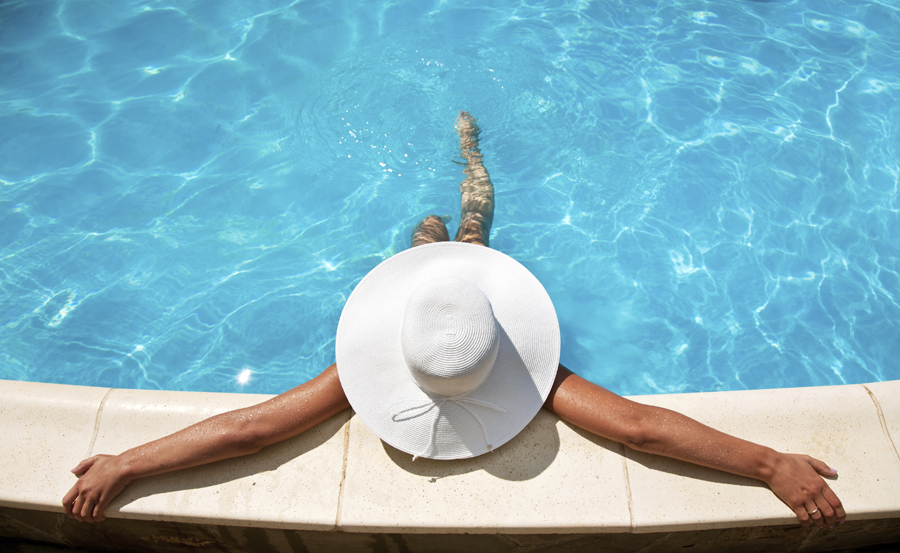Woman in white hat in a swimming pool