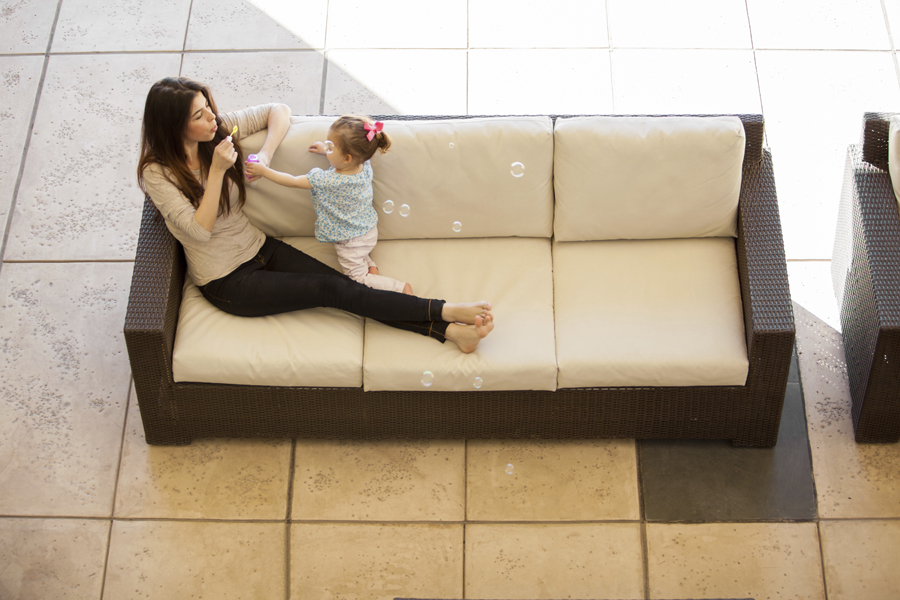 Mom blowing bubbles with daughter on a couch