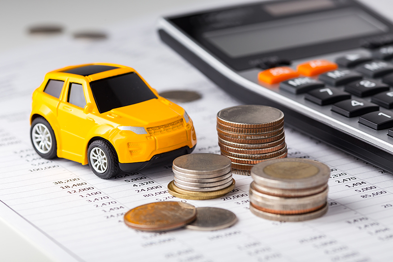 car, money, and calculator on financial sheet