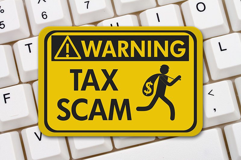 Warning tax scam sign laying on a keyboard