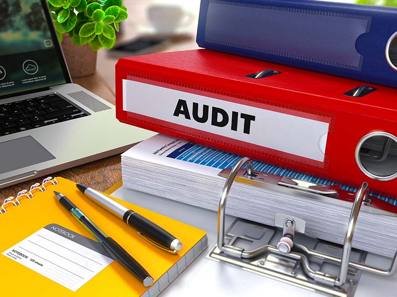 red binder labeled audit
