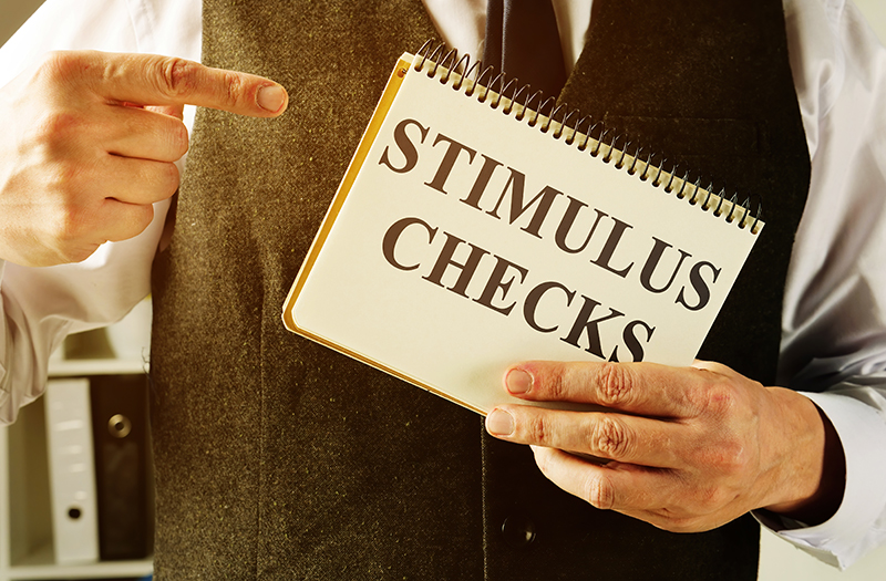Man holding sign saying Stimulus Checks
