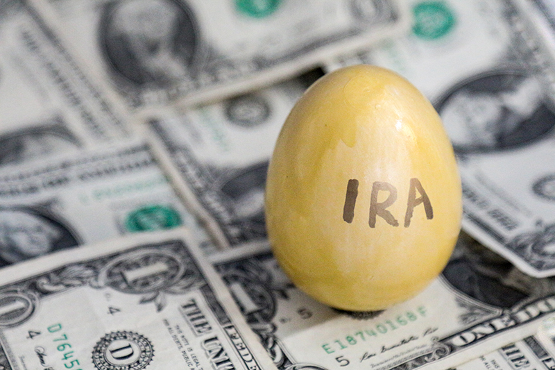 Golden IRA egg sitting on money