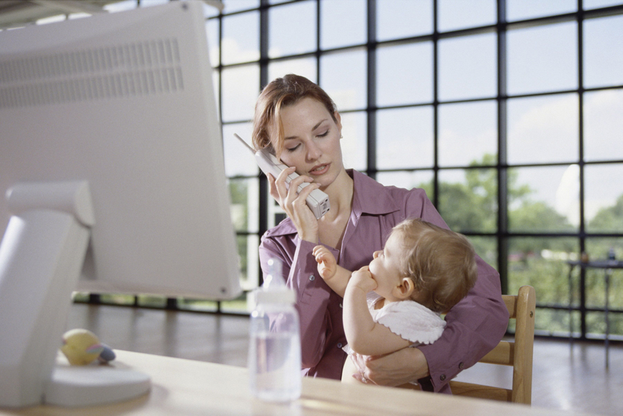 woman on the phone holding baby