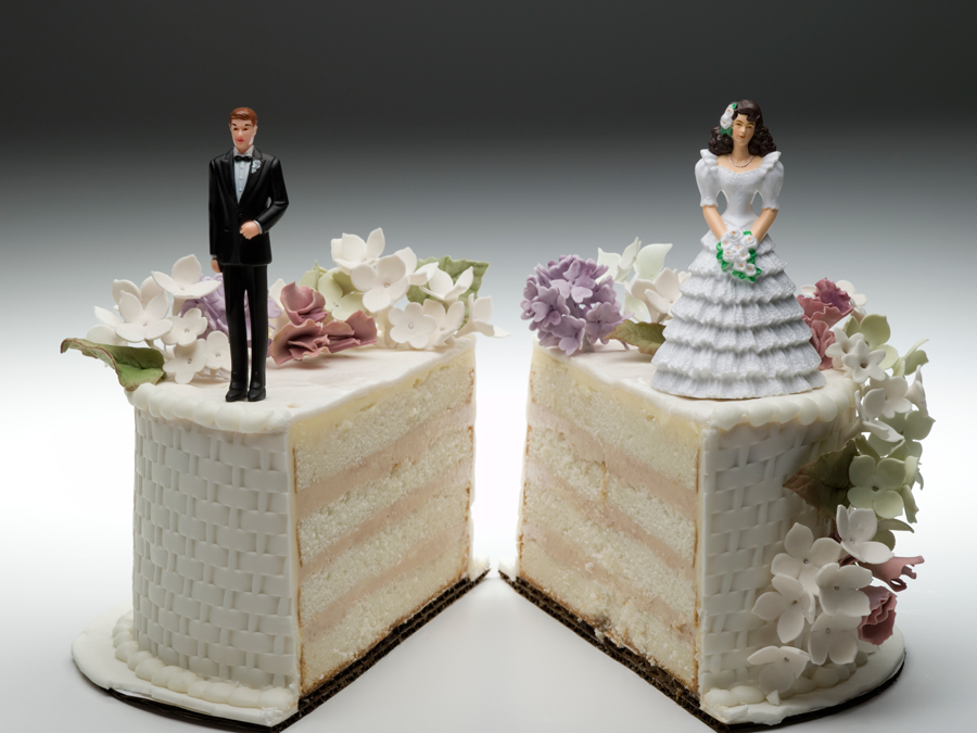 Wedding cake split with the groom on one side and the bride on the other