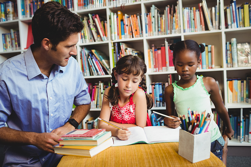 teacher with students in a library