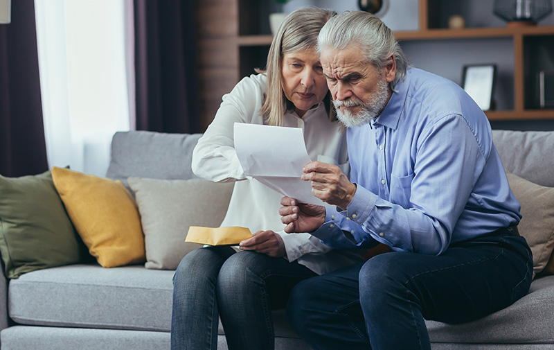 Senior couple reading letter intently