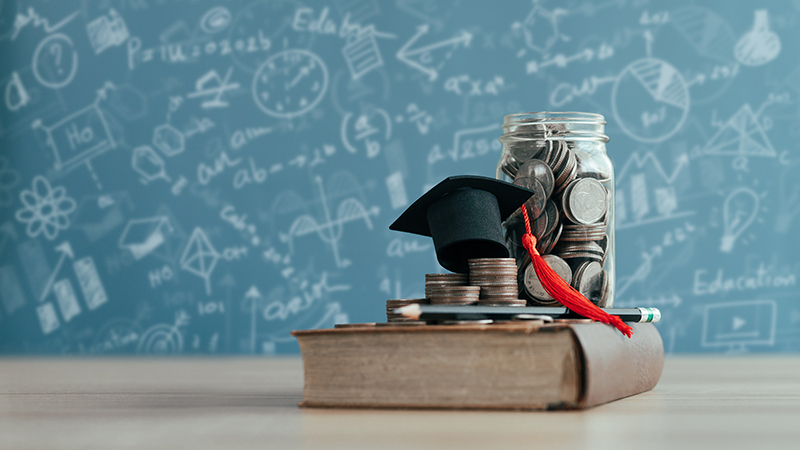 school book with graduation hat and jar of coins on it