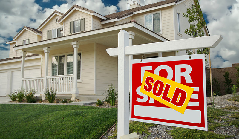 House with a Sold For Sale Sign in Front of it