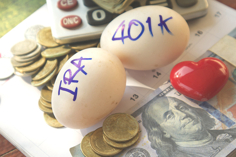 IRA and 401k written on eggs with a money background