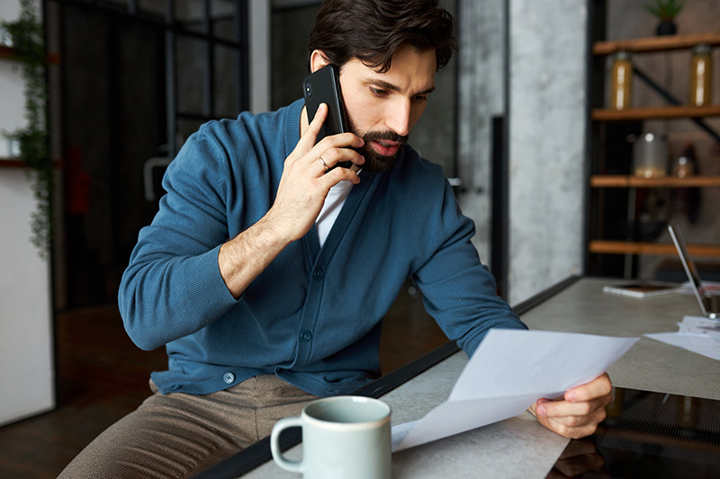 Man on phone while looking at a letter