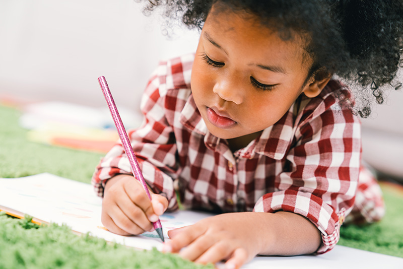 Little girl writing in a notebook