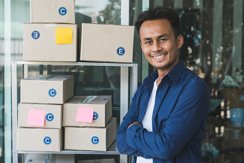 Man Standing By Shipment Boxes