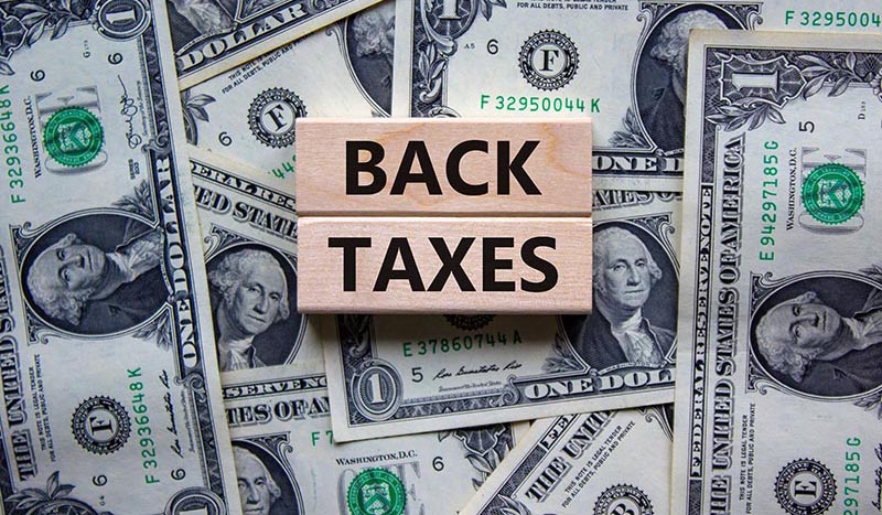 Back Taxes sign with a money background