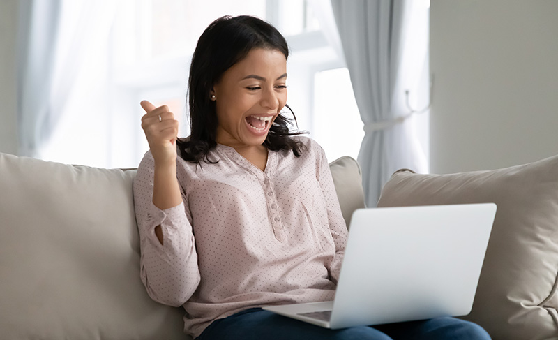 Happy woman looking at her laptop