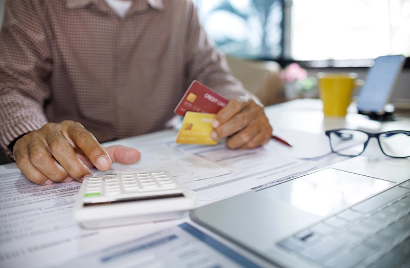 Man doing taxes with Credit Cards in his hand