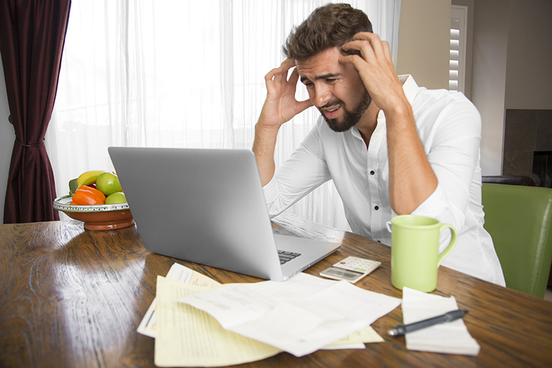 Man looking at computer with a worried look on his face