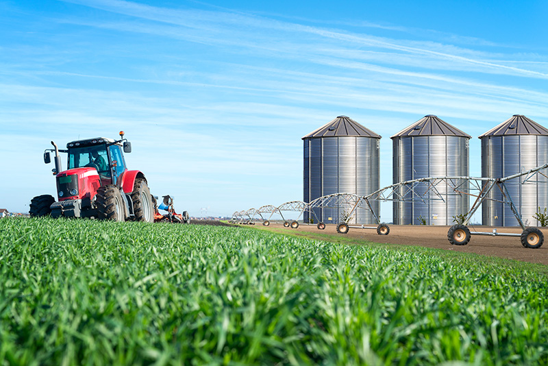 tractor, silos, and watering system on a farm