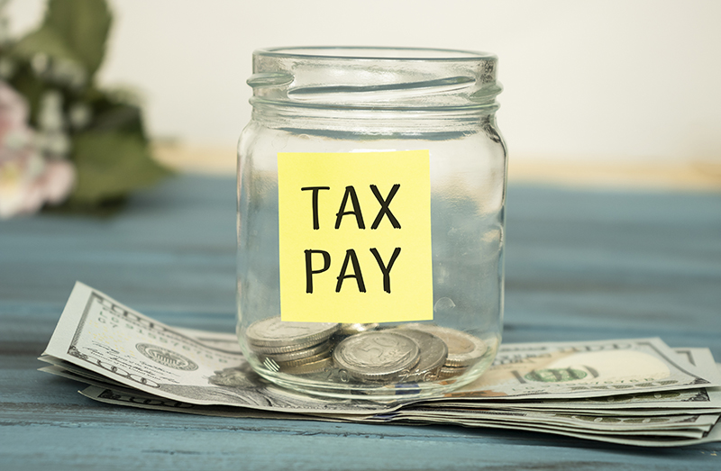 Jar with coins in it that says Tax Pay