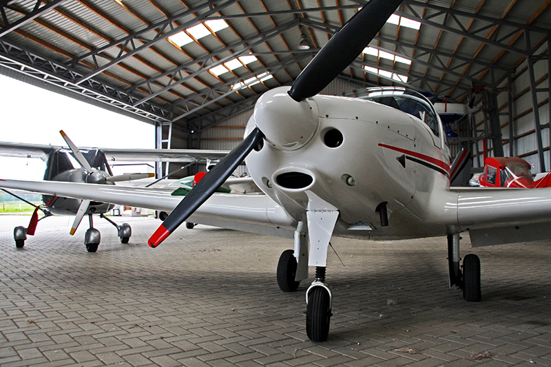 Several small airplanes in a hanger